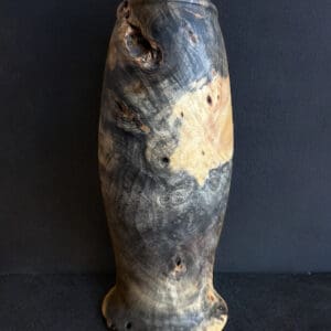 A tall vase with some brown and black spots on it